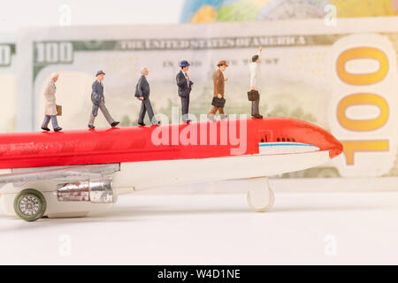 Statuine in miniatura del viaggiatore con orb ,aeroplano e dollar banconota sfondo,il concetto di business Foto Stock