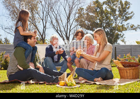 Famiglia estesa con i bambini e i nonni picnic nel giardino Foto Stock