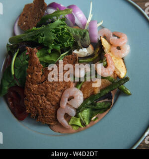 Deliziosa insalata con gamberetti, lattuga, luccio di caviale, cipolla e asparagi. Piastra di turchese. Closeup foto quadrata. Foto Stock