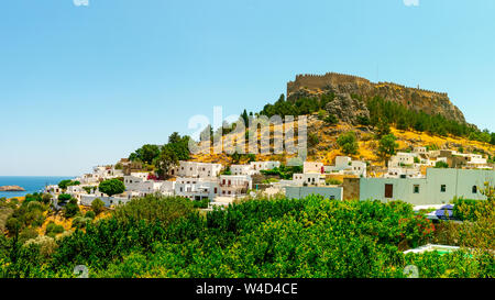 La storica città di Lindos e l'acropoli di Lindos nel bel cielo azzurro a Rodi, Grecia Foto Stock