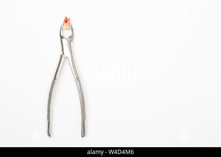 Estrazione del dente con strumenti dentali su sfondo bianco Foto Stock
