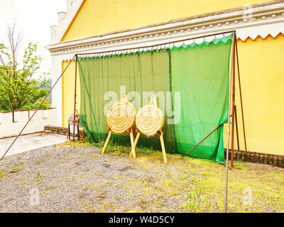 Cerchio di paglia per bersaglio tiro con l'arco trilling, che si trova in un vecchio fienile in legno Foto Stock