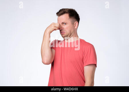 Orinato giovane tappi naso come odori qualcosa puzzano e sgradevole. Foto Stock