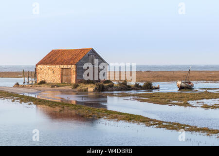 La casa barca in alta marea a Thornham Harbour, Norfolk, Regno Unito Foto Stock