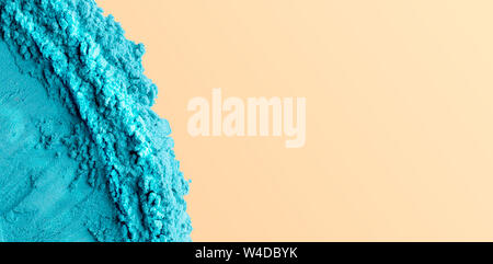 Holi polvere blu come concetto di mare con spiaggia di sabbia Foto Stock