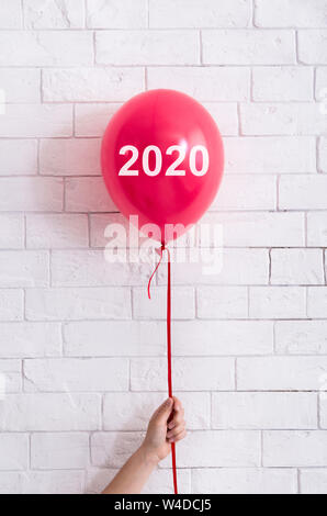 Donna che mantiene luminoso rosso ballon creative con testo bianco Foto Stock