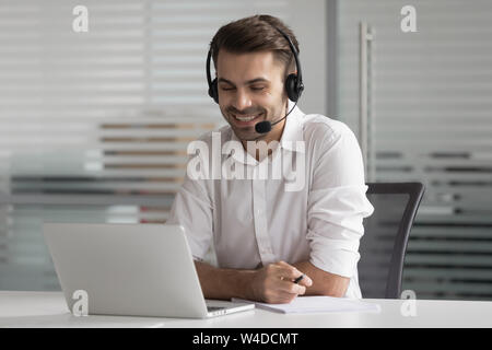 Sorridente uomo d affari di indossare un auricolare wireless fare conferenza chiamata video Foto Stock