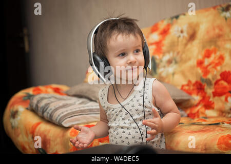 Ragazzo affascinante ascoltare la musica nelle cuffie Foto Stock