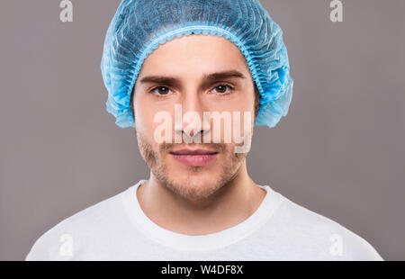Ritratto di giovane uomo in blu medical hat Foto Stock