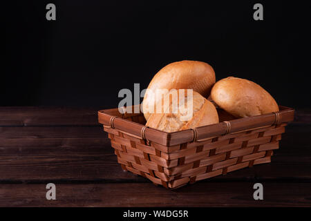 Panini nel cestino del pane su un sfondo di legno, chiave di basso, rustico Foto Stock