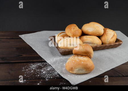 Panini nel cestino del pane su un sfondo di legno, chiave di basso, rustico Foto Stock