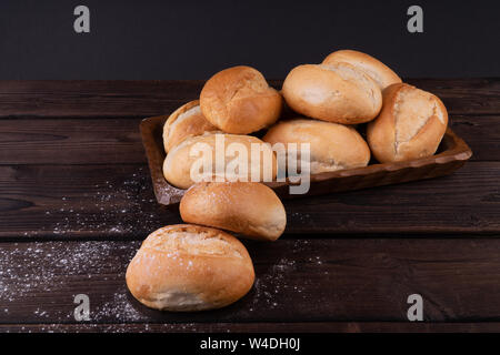 Panini nel cestino del pane su un sfondo di legno, chiave di basso, rustico Foto Stock