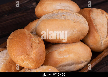 Panini nel cestino del pane su un sfondo di legno, chiave di basso, rustico Foto Stock