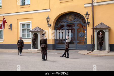 RIGA, Lettonia - 15 Luglio: guardie stanno cambiando in parte anteriore del Castello di Riga, ora residenza presidenziale, luglio 15, 2019 a Riga, Lettonia Foto Stock