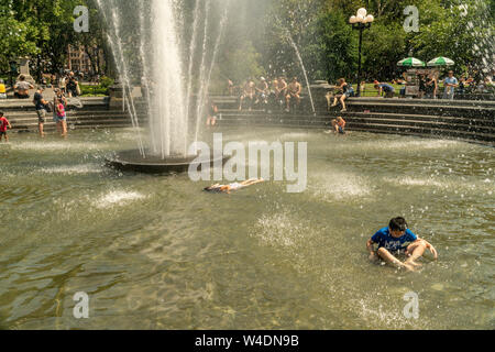 I Newyorkesi e visitatori folleggiare nella fontana di Washington Square Park nel Greenwich Village di New York venerdì 19 luglio, 2019. Un calore eccessivo allarme è in effetti in New York da mezzogiorno di venerdì fino alle 8pm Domenica come oppressiva combinazione di calore e umidità si fanno sentire come 105 gradi F. (© Richard B. Levine) Foto Stock