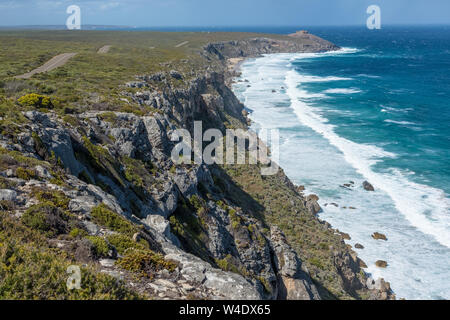 Vista lungo la splendida costa di SW Kangaroo Island con onde che si infrangono sulla riva. In lontananza sono le Remarkable Rocks. Australia Meridionale Foto Stock