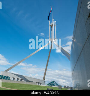 Imponente e moderno polo di bandiera con bandiera australiana battenti alto sopra l'Australia è la sede del Parlamento a Canberra, in atto. Foto Stock