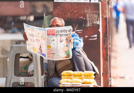 New DELHI - 24 FEBBRAIO: Uomo che legge un Giornale in una strada a Delhi il 24 febbraio. 2018 in India Foto Stock