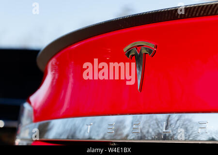 Tesla emblema sul retro del Rosso Modello Tesla S brillante su un luminoso giorno. Foto Stock