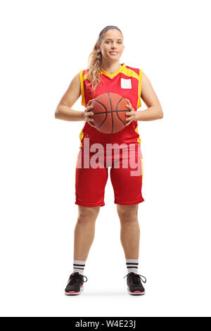 A piena lunghezza Ritratto di una giovane donna giocatore di basket tenendo una palla e guardando la telecamera isolata su sfondo bianco Foto Stock