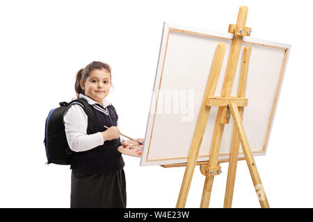 Schoolgirl pittura su una tela di canapa e guardando la telecamera isolata su sfondo bianco Foto Stock