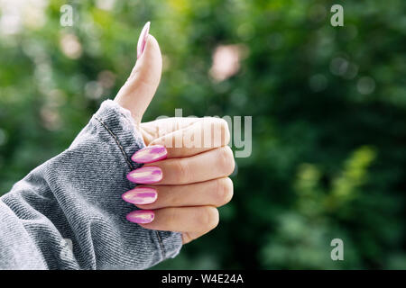 Mano femmina con una bella rosa manicure mostra classe. Foto Stock