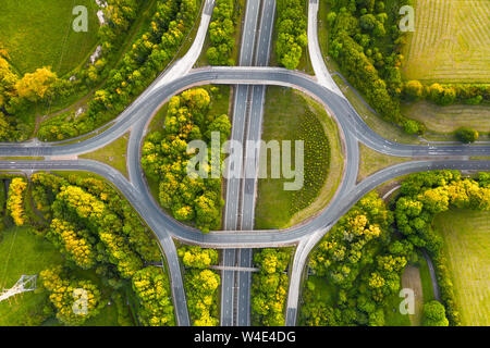 Birds Eye View di un tipico British autostrada intersezione, shot su una tranquilla serata durante il tramonto con assenza di traffico. Foto Stock