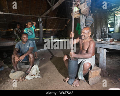 Il capo del villaggio di Nara e qualche famiglia Giovanni Wayhuru rendendo tradizionale budino di Taro nella sua casa chjiefs, Nara, Makira Island, Isole Salomone Foto Stock