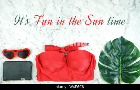 La vacanza estiva concetto flatlay con red accessori femminili su marmo bianco lo sfondo con il divertimento al sole il testo messaggio di saluto. Foto Stock