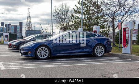 Blu modello Tesla S, rosso Tesla Model S e Rosso Modello Tesla 3 inserito, sovralimentando a Tesla a Grimsby ubicazione. Foto Stock