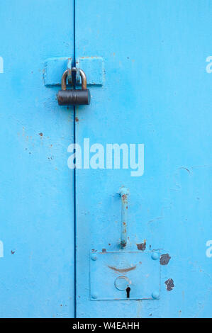 Metallo porta blu con lucchetto. Vecchio garage Cancelli con toppa Foto Stock