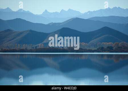 Le montagne si riflette nel lago Benmore, Waitaki Valley, North Otago, Isola del Sud, Nuova Zelanda Foto Stock