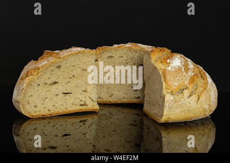 Gruppo di una metà due fette di freschi di forno segale pane di grano isolato sul vetro nero Foto Stock