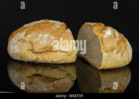 Gruppo di due metà di freschi di forno segale pane di grano un taglio in due isolati su vetro nero Foto Stock
