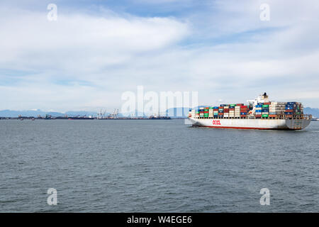 Contenitore navi di proprietà e gestito da Orient Overseas Container Line vicino alla sua destinazione Vancouver, BC proveniente da Kaohsiung, Taiwan. Foto Stock