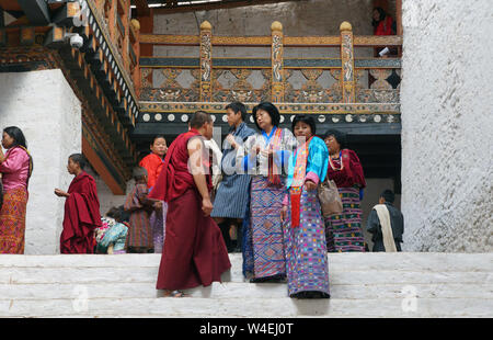 Giovani donne e uomini e monaci in abbigliamento tradizionale in Punakha Dzong durante il Festival Tshechu, Punakha, Bhutan Foto Stock