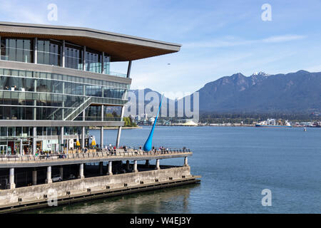 Burrard Landing al Porto di Vancouver visto con alcune strutture industriali attraverso il porto sullo sfondo in una bella giornata di primavera. Foto Stock