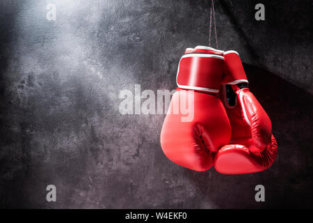 Coppia di red i guantoni appesi al muro Foto Stock