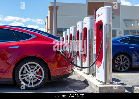 Red Tesla Model S e blu modello Tesla S inserito, carica il file contrapposte alla stazione di sovralimentazione. Foto Stock