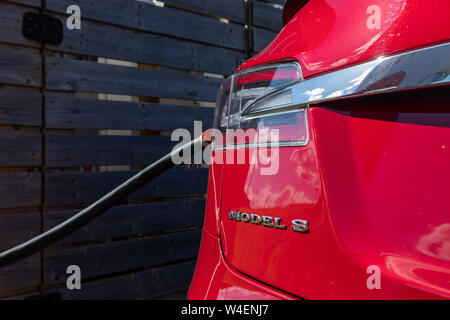 Tesla Model S inserito, carica visto posteriormente con chrome Modello di badge di s. Foto Stock