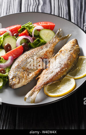 Fried salpe porgy pesce di mare fresco con insalata di verdure close-up su una piastra orizzontale. Foto Stock