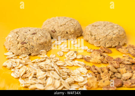 Una sana dolce con snack con cereali e i biscotti su una piastra di colore giallo. Close up e messa a fuoco selettiva. Foto Stock