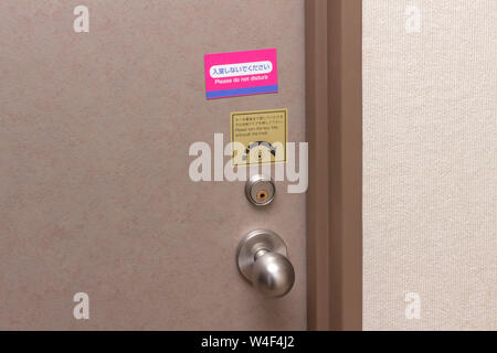 Porta della camera di albergo con il cartello non disturbare(giapponese e inglese) Foto Stock