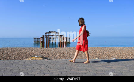 Brighton Regno Unito 23 luglio 2019 - Visitatori al mattino potrete gustare il sole caldo dal Molo Ovest di Brighton . Ondata di caldo in condizioni meteo per il Sud Est della Gran Bretagna con temperature attese per raggiungere la metà degli anni trenta di oggi e nei prossimi giorni . Credito: Simon Dack / Alamy Live News Foto Stock