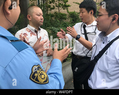 Tokyo, Giappone. 23 Luglio, 2019. Un gruppo di tre persone che sono state mantenendo la sicurezza in prossimità dell' ingresso principale della Sophia University di parlare con un uomo che era parte di un rally al collegio stesso. Un gruppo di studenti hanno protestato presso il licenziamento di un insegnante che è stato licenziato dalla Università per ragioni poco chiare. Secondo un portavoce della Sophia University A. Kikuchi ha detto che si tratta di un tema che è in discussione da parte di avvocati di entrambe le parti e che non è noto quando avranno una risoluzione. Il nome dell'insegnante è il dottor Kuki Choo che, secondo alcuni studenti della stessa Università, essi g Foto Stock