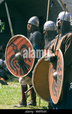 Staraya Ladoga, San Pietroburgo, Russia - 22 Giugno 2019: fila di vichinghi con scudi e spade vestito in mail a catena Foto Stock