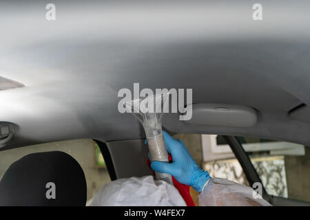 Lavaggio a secco salon auto. Lavoratore utilizza il vuoto di lavaggio in auto Foto Stock