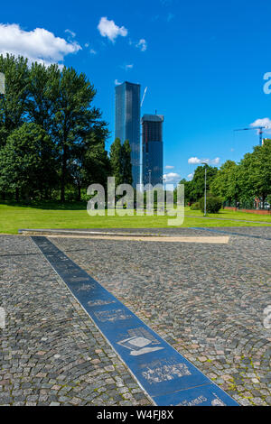 La piazza di Deansgate blocchi di appartamenti in costruzione (Jun 19) e Hulme persone storia dell'illustrazione in Hulme Park, Manchester, Inghilterra, Regno Unito. Foto Stock