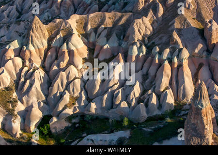 Colorate formazioni rocciose situato sul pendio di una collina vicino a Goreme nella regione della Cappadocia della Turchia. Infine queste formazioni diventerà fata camino Foto Stock