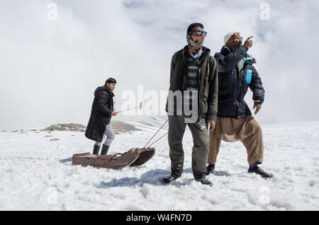 Tourist prende un selfie come gli estrattori di slitta fanno il loro dovere in Gondola Gulmarg Fase 2 / Apharwat picco, Gulmarg, Jammu e Kashmir India Foto Stock